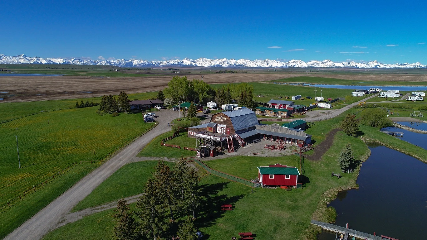 Paisagem rural no Canadá com rancho em Alberta e as Montanhas Rochosas ao fundo, representando qualidade de vida e oportunidades para imigrantes